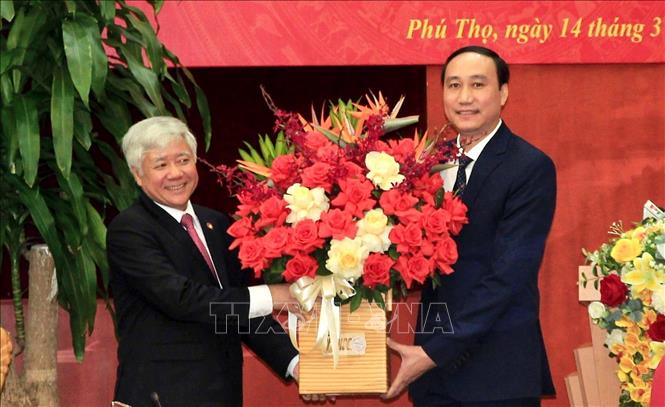 Bí thư Trung ương Đảng, Chủ tịch Ủy ban Trung ương MTTQ Việt Nam Đỗ Văn Chiến (bên trái) tặng hoa chúc mừng đồng chí Phó Bí thư Tỉnh ủy Phùng Khánh Tài. Ảnh: Trung Kiên/TTXVN