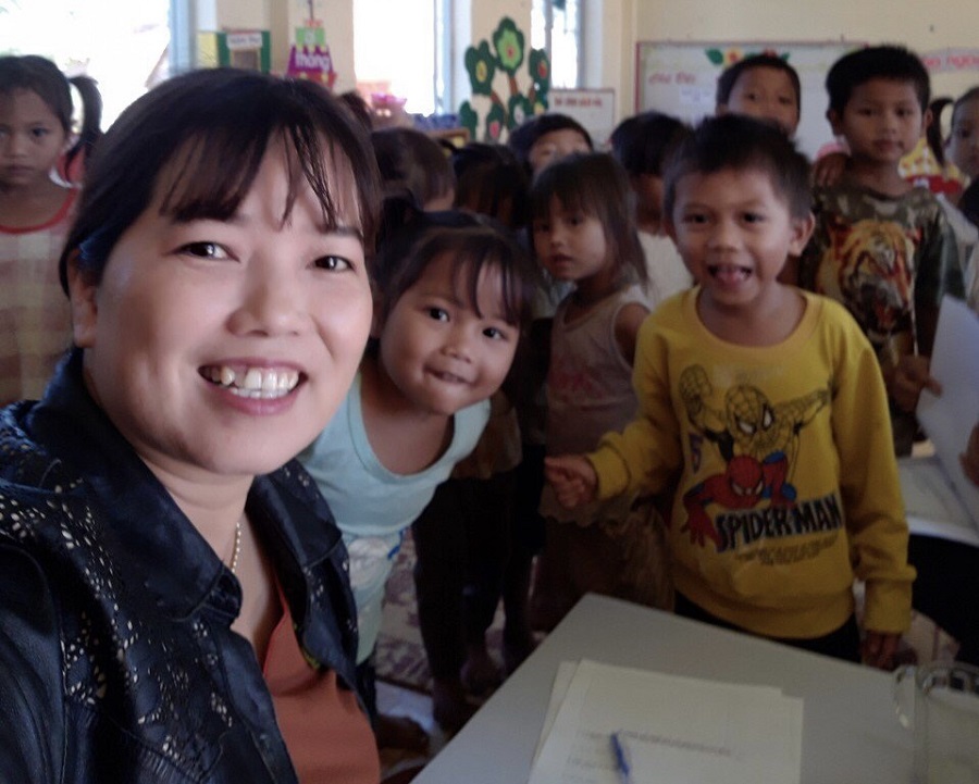 Cô giáo Hoàng Thị Xuân Thiện cùng trẻ em Trường Mầm non Đăk Ui.