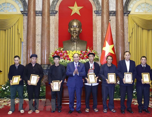 Chủ tịch nước Nguyễn Xuân Phúc tặng chân dung Chủ tịch Hồ Chí Minh cho đại biểu người có uy tín tiêu biểu tỉnh Hà Giang. (Ảnh: Thống Nhất/TTXVN).