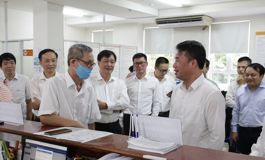 Tổng Giám đốc Nguyễn Thế Mạnh trao đổi với người dân đến làm việc qua tính năng đặt lịch làm việc trực tuyến tại bộ phận Một cửa BHXH TP. Hồ Chí Minh.