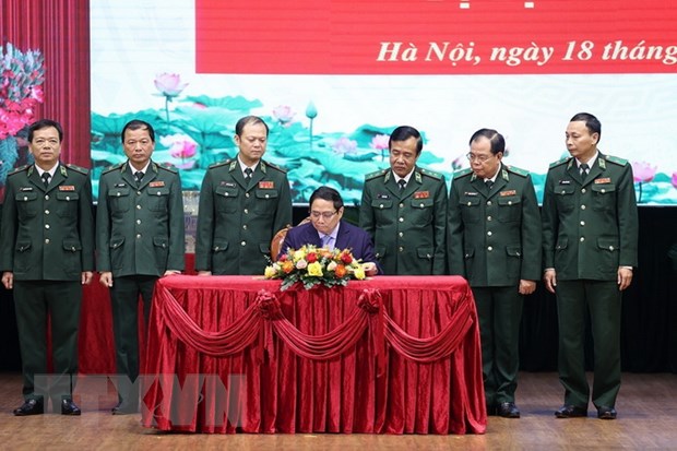 Thủ tướng Phạm Minh Chính viết sổ lưu niệm khi đến thăm và làm việc với Bộ Tư lệnh Bộ đội Biên phòng. (Ảnh: Dương Giang/TTXVN).