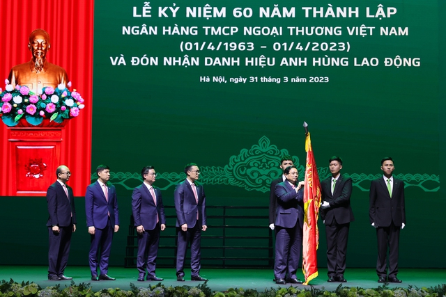 Thay mặt lãnh đạo Đảng và Nhà nước， Thủ tướng Phạm Minh trao tặng ngân hàng Vietcombank danh hiệu Anh hùng Lao động - Ảnh: VGP/Nhật Bắc.