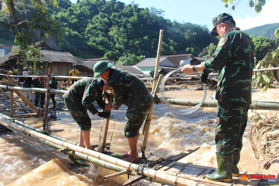 Cán bộ, chiến sĩ lực lượng vũ trang huyện Kỳ Sơn, Nghệ An bắc cầu tạm qua suối Huồi Giảng sơ tán học sinh bị mắc kẹt tại bản Hòa Sơn, xã Tà Cạ đến nơi an toàn.