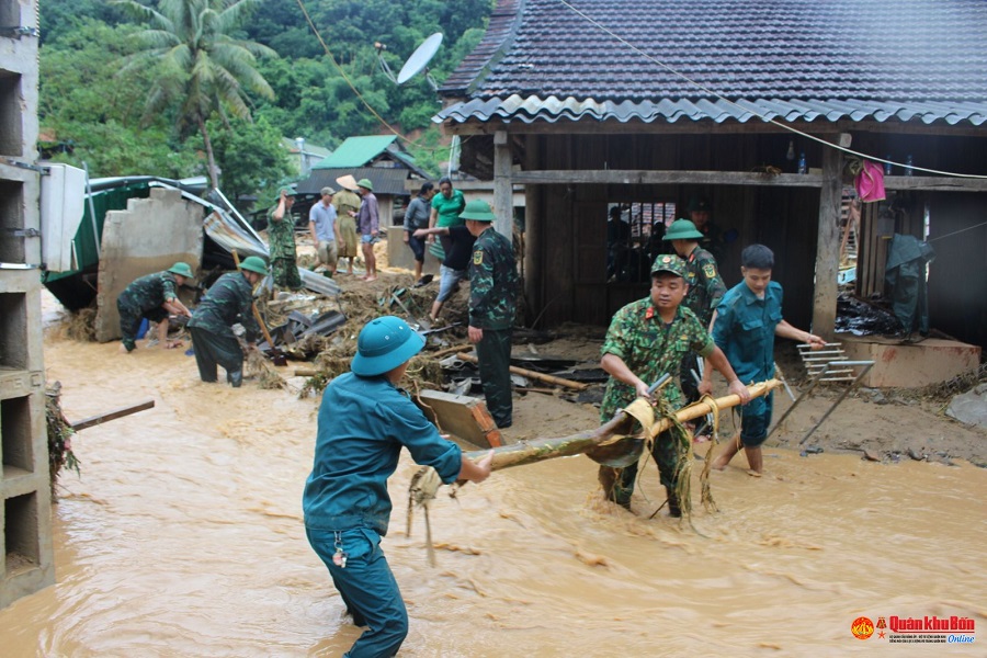 Giúp người dân tìm kiếm tài sản trong đống đổ nát sau cơn lũ.