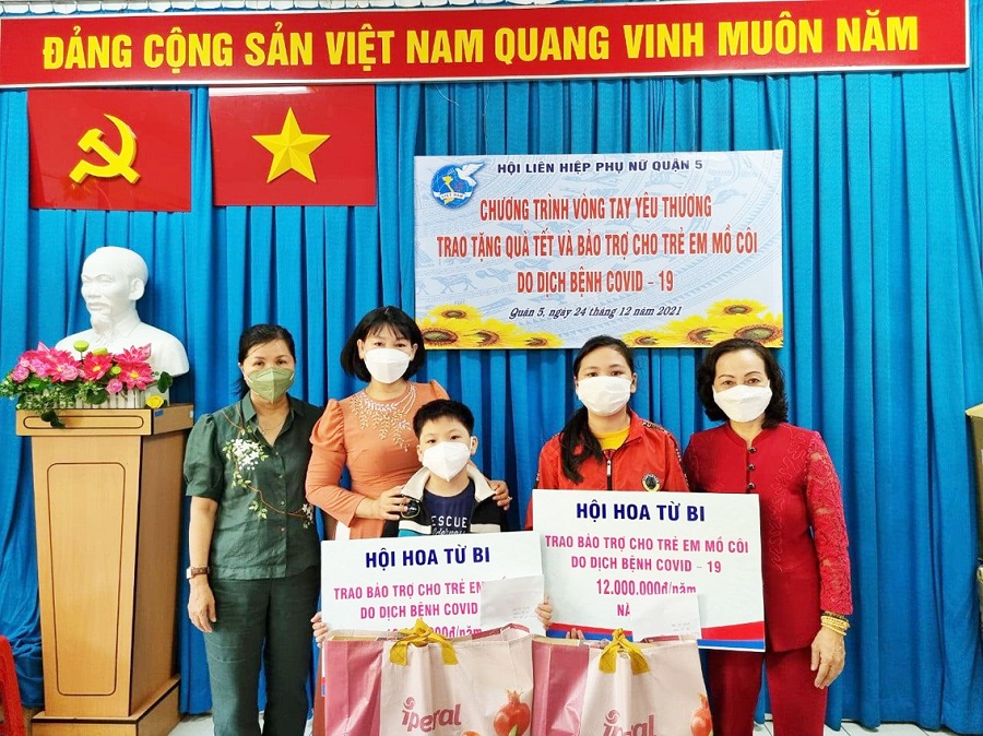 Chị Nguyễn Vũ Song Hòa (bìa phải) trao bảo trợ cho trẻ mồ côi vì COVID-19 tại quận 5.