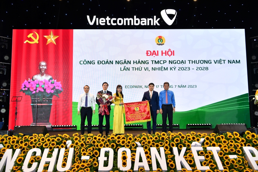 Đ/c Huỳnh Thanh Xuân – Phó Chủ tịch Tổng Liên đoàn Lao động Việt Nam (ngoài cùng bên phải) tặng Cờ Thi đua của Tổng Liên đoàn Lao động Việt Nam và đ/c Đỗ Việt Hùng – Phó Bí thư thường trực Đảng ủy Vietcombank (ngoài cùng bên trái) tặng hoa cho đại diện Công đoàn Vietcombank