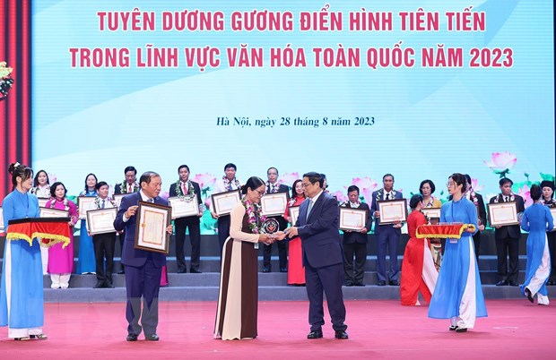 Thủ tướng Phạm Minh Chính trao biểu trưng vinh danh các gương điển hình tiên tiến trong lĩnh vực văn hóa. (Ảnh: Dương Giang/TTXVN).
