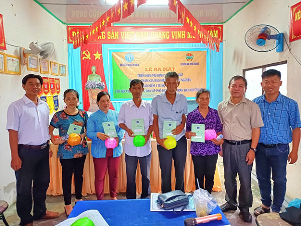 Ông Phạm Hùng Dũng - Giám đốc BHXH huyện Trần Đề  cùng Lãnh đạo Hội Nông dân, chính quyền địa phương trao tặng heo đất cho hội viên nông dân để tiếp tục tích lũy tham gia BHXH tự nguyện.